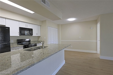 Kitchen featuring visible vents, white cabinets, a