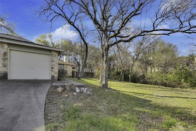 View of yard with concrete driveway, a garage, an