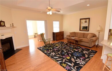 The spacious living room features a fireplace and a trey ceiling detail.