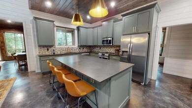 Kitchen featuring wood ceiling, wooden walls, gray