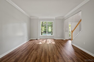 Spare room featuring crown molding and dark hardwo