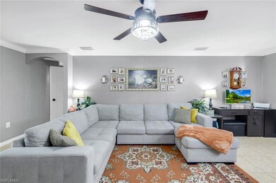 Tiled living room featuring crown molding and arched walkways