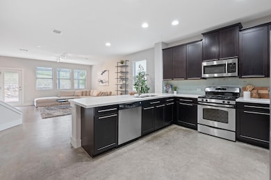 Kitchen featuring finished concrete floors, appli