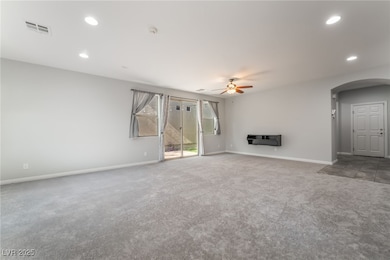 Large family room featuring arched walkways, carpe