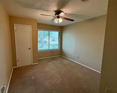 Spare room featuring a ceiling fan, a textured ce