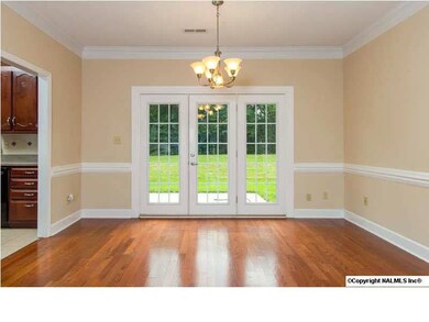 The formal dining area also has new hardwood flooring. It is accentuated by a chair rail, crown molding and French doors leading out to the patio.