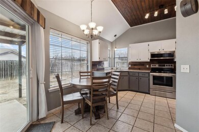 Kitchen with lofted ceiling, a notable chandelier,