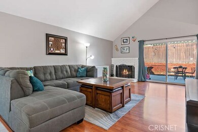 Living room with vaulted ceiling, laminate floor and fireplace.
