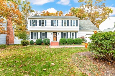 Colonial-style house with a garage and a front law