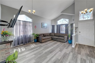 Living room featuring a chandelier, high vaulted c