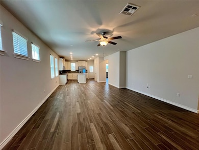 Unfurnished living room featuring dark wood-style flooring, a ceiling fan, and recessed lighting
