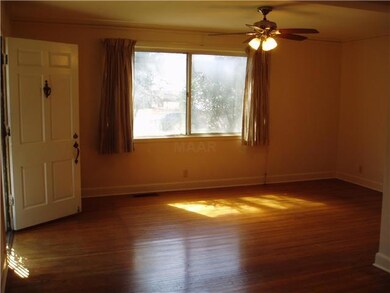 The living room is spacious and has a nice hardwoo