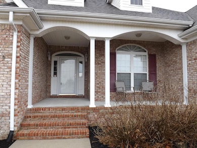 Covered front porch with sidewalk leading to driveway.