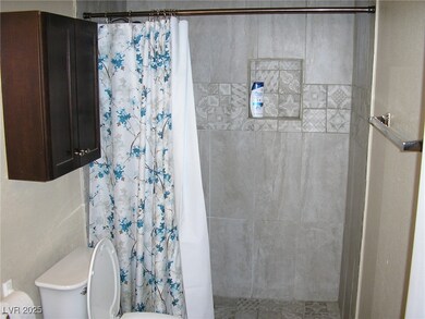 Bathroom featuring a tile shower and toilet