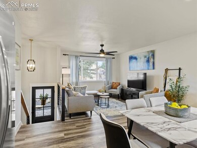 Living area featuring wood finished floors, a ceiling fan, and a chandelier
