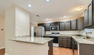 Kitchen featuring light hardwood / wood-style floors, tasteful backsplash, kitchen peninsula, and stainless steel appliances