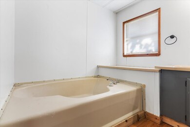 Full bath featuring a garden tub and wood finished floors