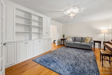 Living room featuring crown molding and light wood