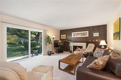 Living room warmed by the fireplace with serene views of back yard.
