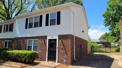 View of front of property featuring fence, driveway, and brick siding