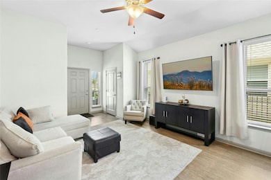 Living room with light wood finished floors and a ceiling fan