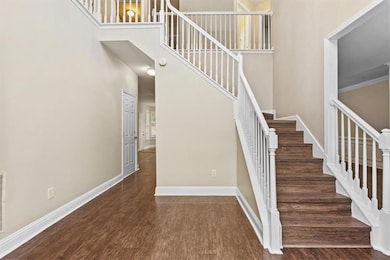 Stairs with wood finished floors and a towering ceiling