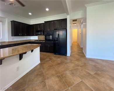 Kitchen featuring black appliances, light stone co