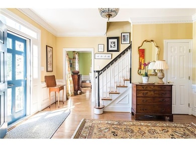 Front entryway with heavy moulding and wood floors