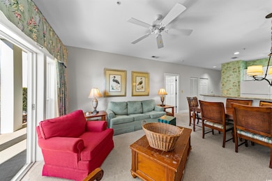 Carpeted living room featuring ceiling fan