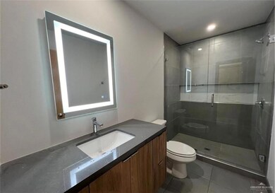 Bathroom featuring tile patterned flooring, vanity, toilet, and a stall shower