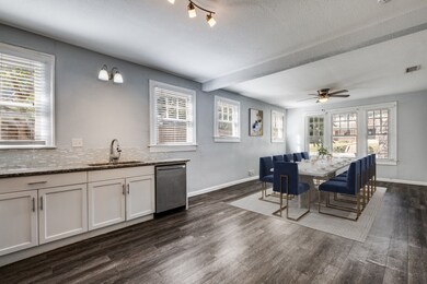 Dining room with dark wood finished floors, a textured ceiling, beam ceiling, and ceiling fan