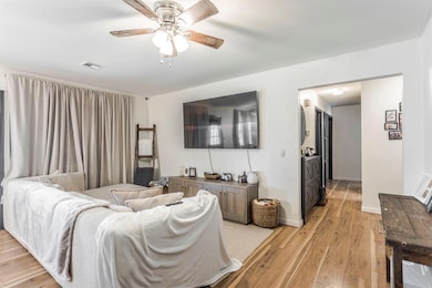 Living room with light wood finished floors and ceiling fan