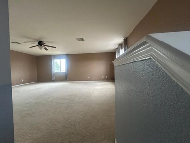 Carpeted empty room featuring ceiling fan, basebo