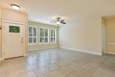 Entryway featuring ceiling fan, light tile patter