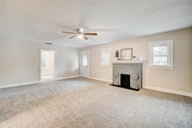 Looking toward the front door.  That fireplace is a stunner.  The room in the distance is bedroom #3.