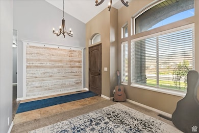 Entryway with tile patterned floors, high vaulted ceiling, and a chandelier