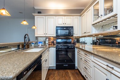 Kitchen featuring black appliances, decorative lig