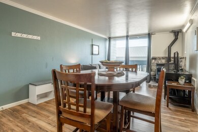 Dining room with light wood-type flooring, crown molding, and a wall of windows