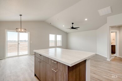 Kitchen featuring open floor plan, light wood finished floors, brown cabinetry, a center island, and recessed lighting