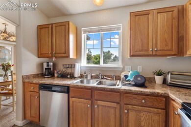 Kitchen with stainless steel dishwasher, plenty of natural light, and brown cabinets