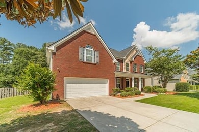 Traditional-style house with a garage, concrete driveway, and brick siding