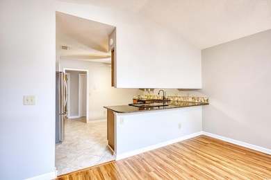Kitchen with a sink, dark countertops, light wood 