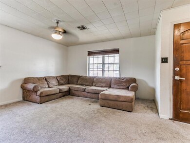 Carpeted living room featuring ceiling fan