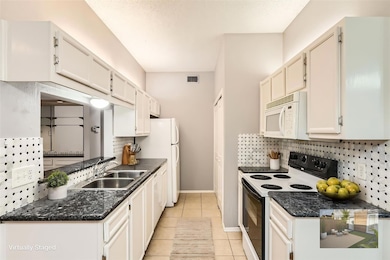 Kitchen featuring white appliances, a sink, decor