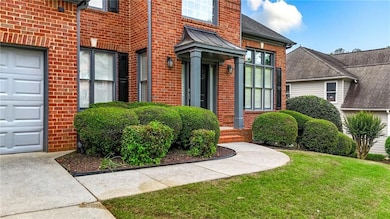View of exterior entry with brick siding and a yard