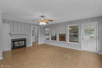 Unfurnished living room with ceiling fan, washer /