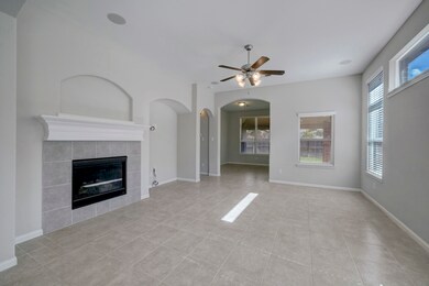Main living area with gas fireplace. Built in Surround sound speakers. Plenty of entertaining space. Back of photo is Office/Flex Space with backdoor to Covered Porch and Backyard.