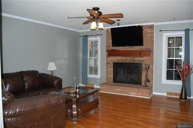 LIVING ROOM WITH HARDWOODS AND WOOD BURNING FIREPL