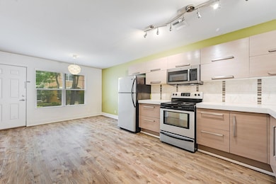 Kitchen featuring stainless steel appliances, lig