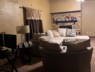 Living room with a brick fireplace and carpet